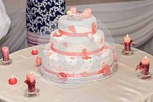 Baptize cake with sugar shoes and burning candles photo