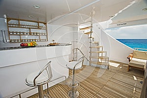 Bar area with stools on deck of a luxury motor yacht
