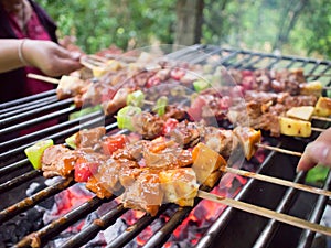 Bar-B-Q or BBQ with kebab cooking. coal grill of pock meat skewers with pineapple and green pepper. barbecuing dinner.