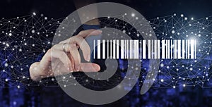 Bar Code Price Tag Merchandise Concept. Hand hold digital hologram Bar Code Price Tag sign on city dark blurred background.