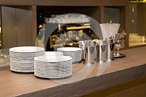 Bar counter with clean dishes close up. Barroom in restaurant, ready for work. Cafe background. Kitchen utensils, cookware cups,