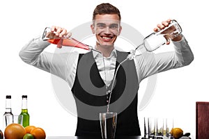 An attractive bartender at a bar counter doing a cocktail, a plate of lime isolated on a white background.