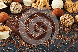 Bar of dark chocolate close up and variety of candy