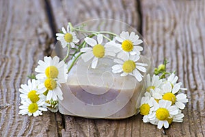 Bar of natural soap and chamomile flowers