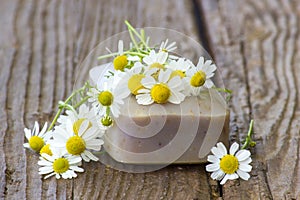 Bar of natural soap and chamomile flowers