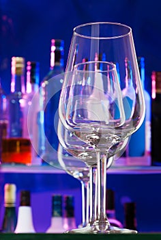 Bar shelf and transparent wine glasses in a row