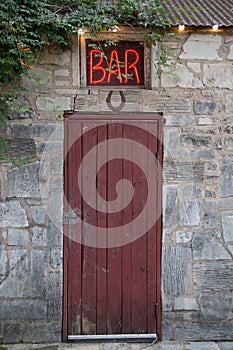 Bar Sign Above Red Door