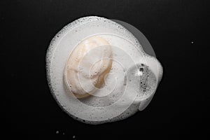 Bar of soap with foam isolated on black