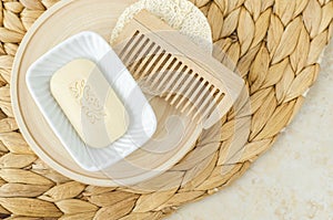 Bar of soap (solid shampoo), wooden hairbrush (comb) and loofah bath sponge. Eco friendly toiletries.