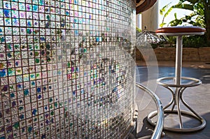 Bar stool in front of colorful mosaic wall