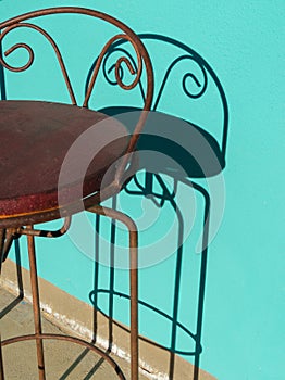 Bar stool and shadow, colorful wall