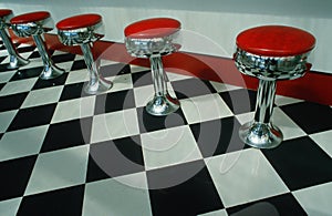 Bar stools and checkered floor in diner photo