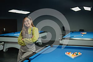 bar worker smiling while standing on the pool at the biliard studio