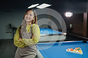 bar worker smiling while standing on the pool at the biliard studio