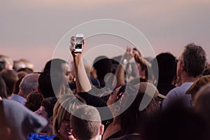 Crowd taking pictures with cell phones, event.