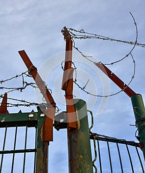 Barbed wire on a rusted iron gate