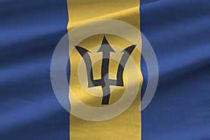 Barbados flag with big folds waving close up under the studio light indoors. The official symbols and colors in banner