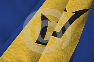 Barbados flag with big folds waving close up under the studio light indoors. The official symbols and colors in banner