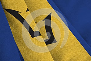 Barbados flag with big folds waving close up under the studio light indoors. The official symbols and colors in banner