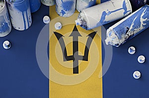 Barbados flag and few used aerosol spray cans for graffiti painting. Street art culture concept