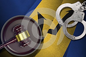 Barbados flag with judge mallet and handcuffs in dark room. Concept of criminal and punishment, background for judgement