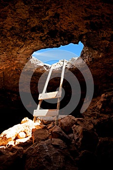 Barbaria cape cave hole with rustic ladder on wood photo