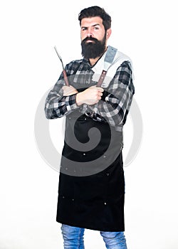 Barbecue accessories. Bearded man holding grill gripper tools. Hipster in apron with metal utensils for barbecue grill photo