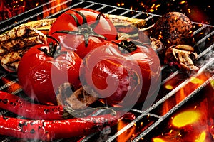 Barbecue bbq grilled tomatoes, zucchini, chili, champignons, halves of garlic. Flaming fire, ember charcoal and smoke