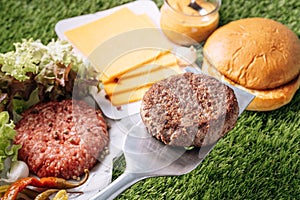 Barbecue burger cutlet. barbeque concept in nature. barbecue spatula with a burger patty on it