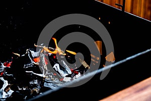 Barbecue charcoals.BBQ Grill Pit With Glowing And Flaming Hot Charcoal Briquettes.Burning flames over barbecue