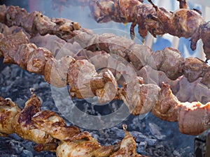 Barbecue cooking. Meat is fried on a spit. Street food grill.