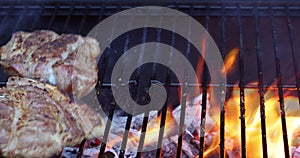 Barbecue cooking open fire in bonfire flame with juicy pork steak fried fire coals grill flame