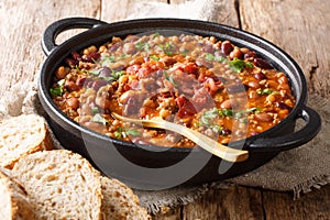 Barbecue cowboy beans with ground beef, bacon in a spicy sauce closeup the table. horizontal