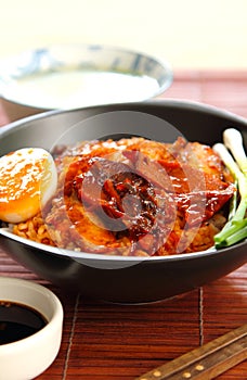 Barbecue and crispy pork with gravy sauce on rice photo