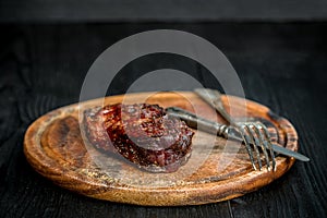 Barbecue Dry aged Ribeye Steak with knife and fork on cutting board