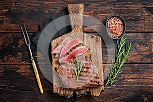 Barbecue dry aged wagyu Flank Steak on a cutting board. Wooden background. Top view