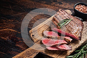 Barbecue dry aged wagyu Flank Steak on a cutting board. Wooden background. Top view. Copy space