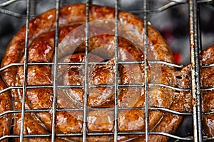 Barbecue with fire sausages on the grill. Raw chevapchichi sausages are grilled over an open fire on the street