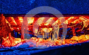 Barbecue grill and burning coals in the background, side view. Outdoor barbecue concept