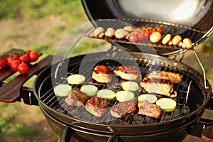 Barbecue grill with meat and vegetables outdoors, closeup. Camping cookout