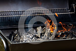 Barbecue grill pit with glowing and flaming hot open fire with red flame