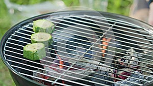 Barbecue grill. Putting marrows on grate