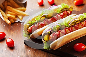 Barbecue grilled hot dog with sausage and ketchup on wooden kitchen board. Traditional american fast food.