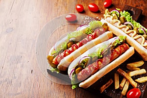 Barbecue grilled hot dog with sausage and yellow mustard with ketchup on wooden board. Traditional american fast food.