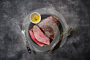 Barbecue Grilled rump cap or brazilian picanha beef meat steak in a wooden tray. Grey background