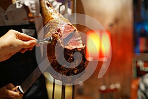 Barbecue leg of lamb on skewer - Churrasco Brazilian BBQ cooked on the rotisserie served by cutting meat directly off skewers