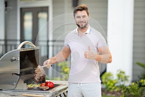 Barbecue master. Middle aged hispanic man in apron for barbecue. Roasting and grilling. Man hold cooking utensils