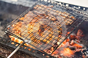 Barbecue meat cooking on fire - the ingredient of bun cha the famous Vietnamese noodle soup with bbq meat, spring roll, vermicelli