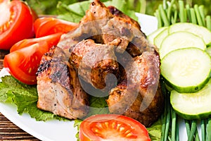 Barbecue meat, vegetables and greens on a plate