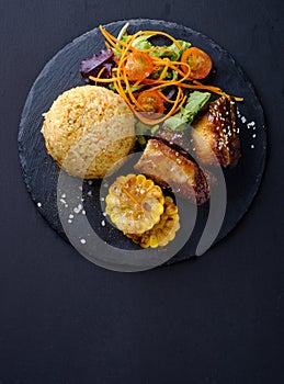 Barbecue pork ribs with rice, salad and corn, top view